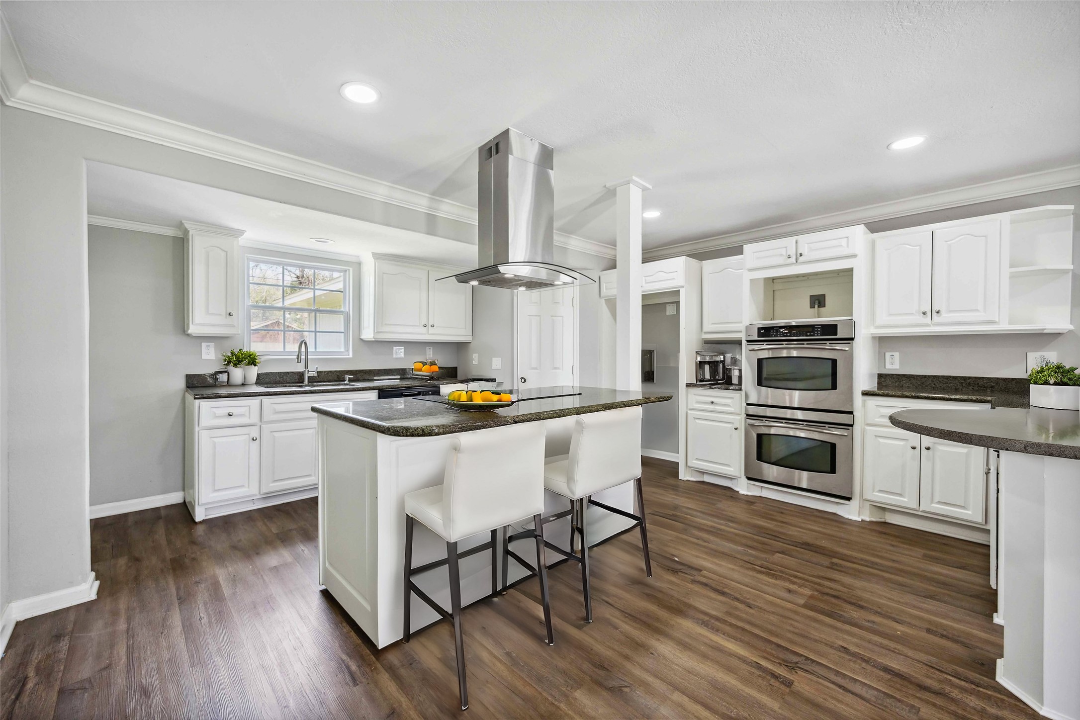7150 Mobud Drive Houston, TX 77074 - Photo 4 of 29 a kitchen with granite countertop a stove a sink dishwasher a refrigerator and white cabinets with wooden floor