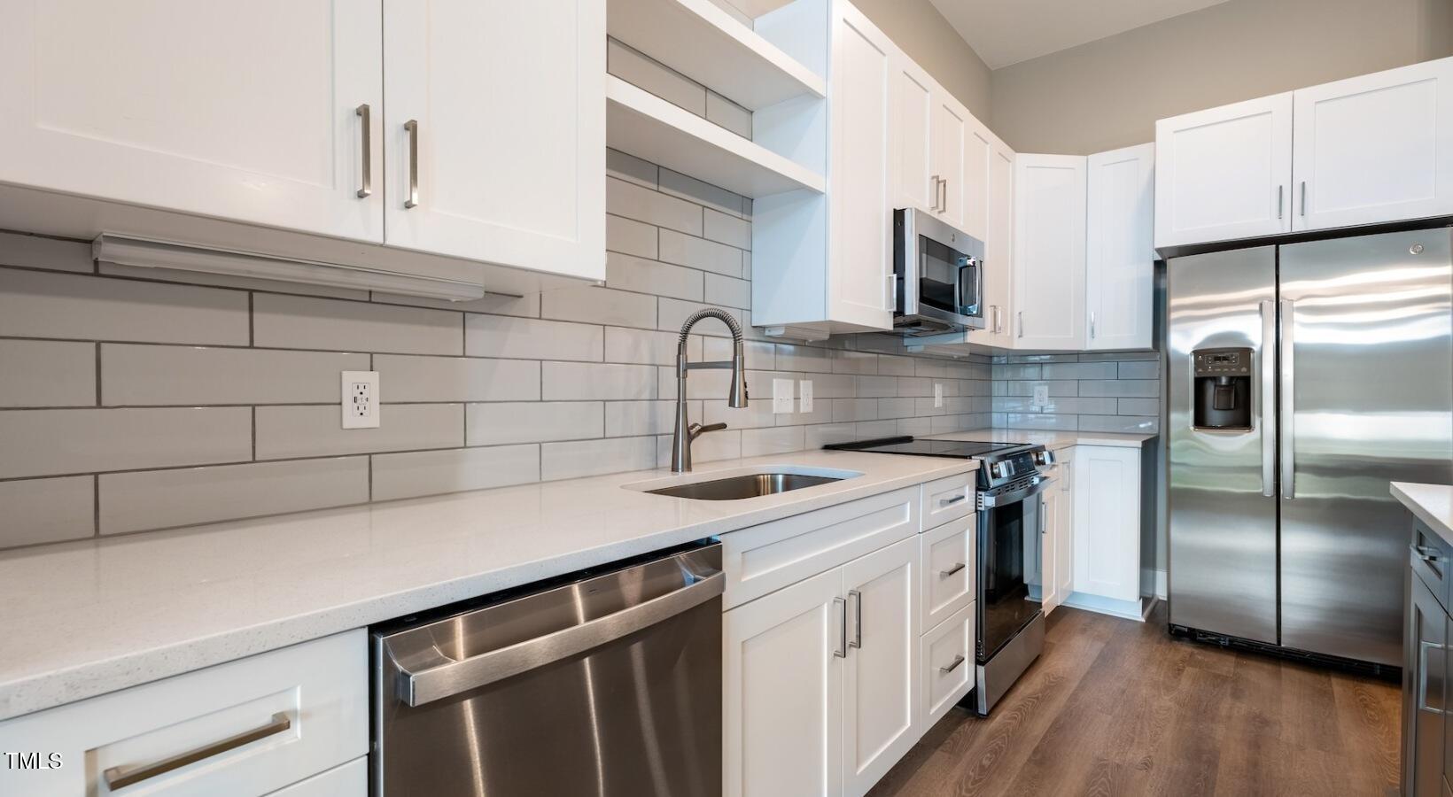 255 East Chatham Street, Unit A1 Cary, NC 27511 - Photo 24 of 31 a kitchen with stainless steel appliances a sink stove and refrigerator