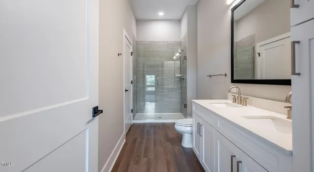 a bathroom with a double vanity sink toilet and shower