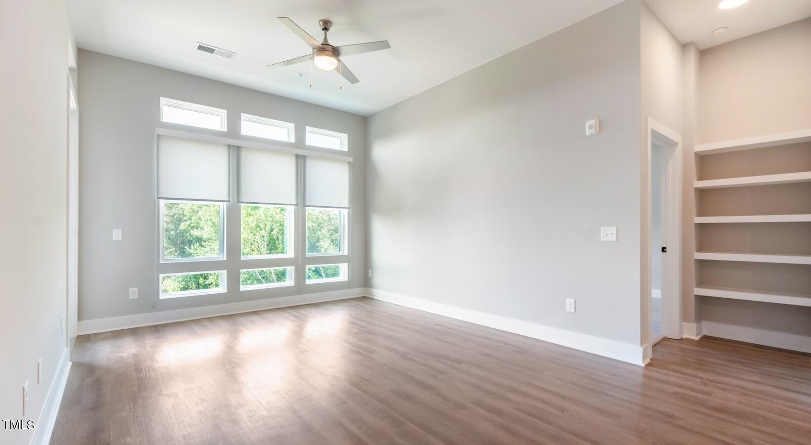 255 East Chatham Street, Unit A1 Cary, NC 27511 - Photo 8 of 31 wooden floor in an empty room with a window