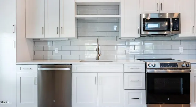 a kitchen with cabinets stainless steel appliances and a sink