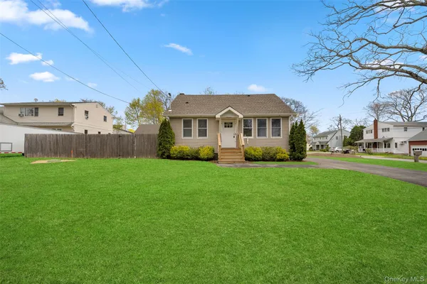 a front view of a house with a garden and trees