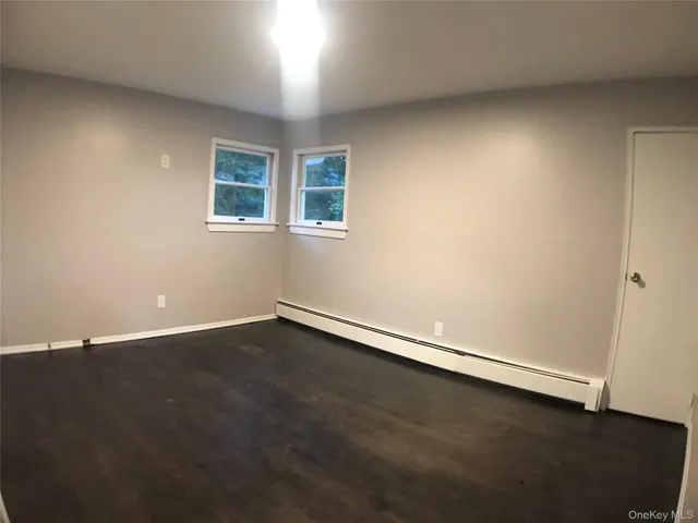 a view of a room with wooden floor and a window