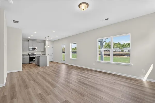 a kitchen with granite countertop a refrigerator stove top oven and sink