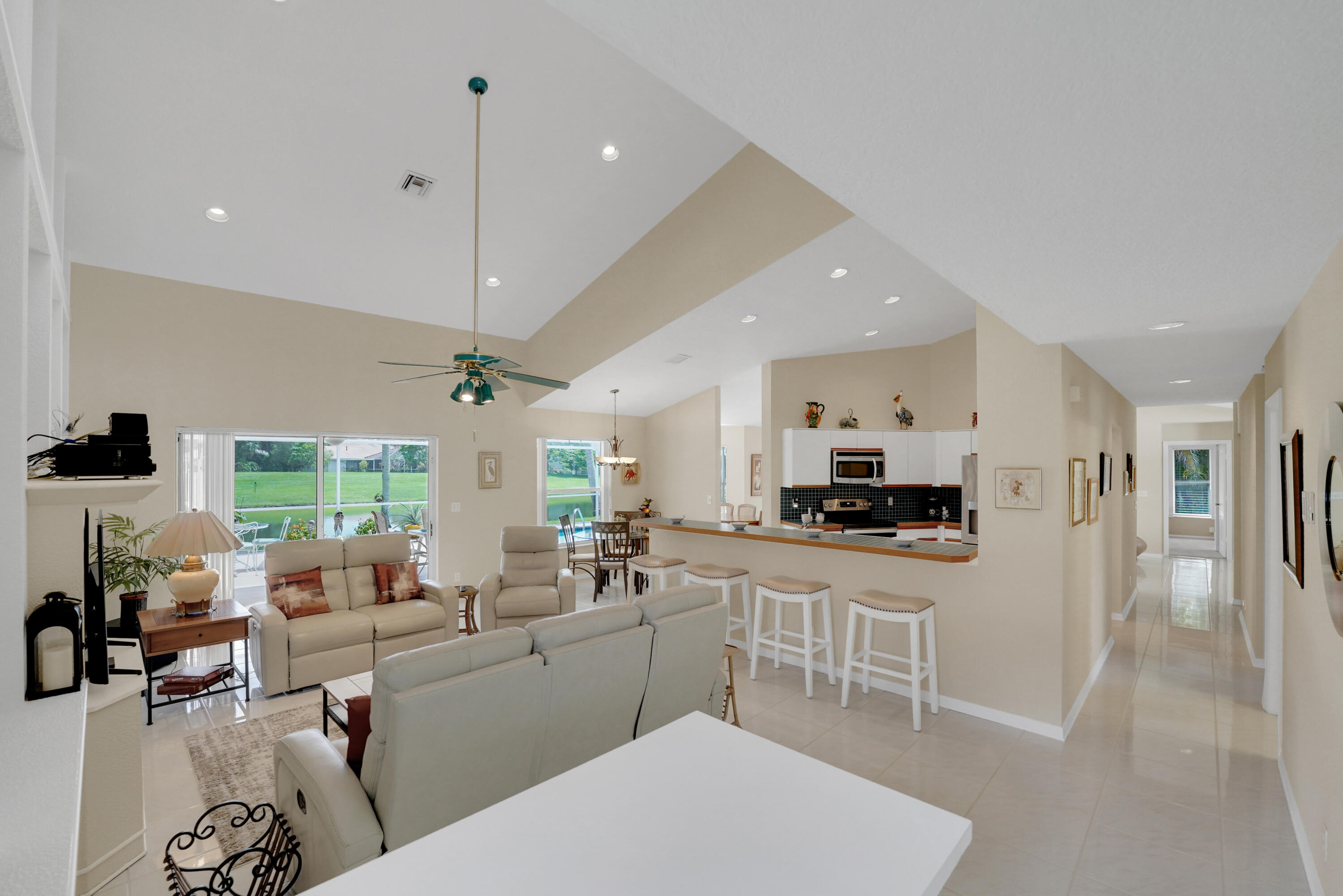 22331 Kettle Creek Way Boca Raton, FL 33428 - Photo 26 of 86 a large white kitchen with stainless steel appliances granite countertop a stove a sink dishwasher a dining table and chairs with wooden floor