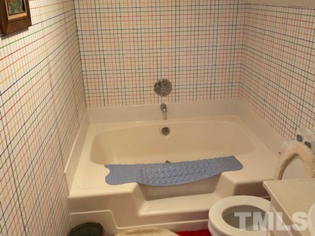 1164 Keith Hills Road Lillington, NC 27546 - Photo 44 of 47 a bathroom with a granite countertop bathtub and sink