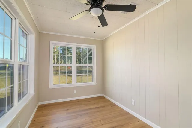 an empty room with a window and ceiling fan