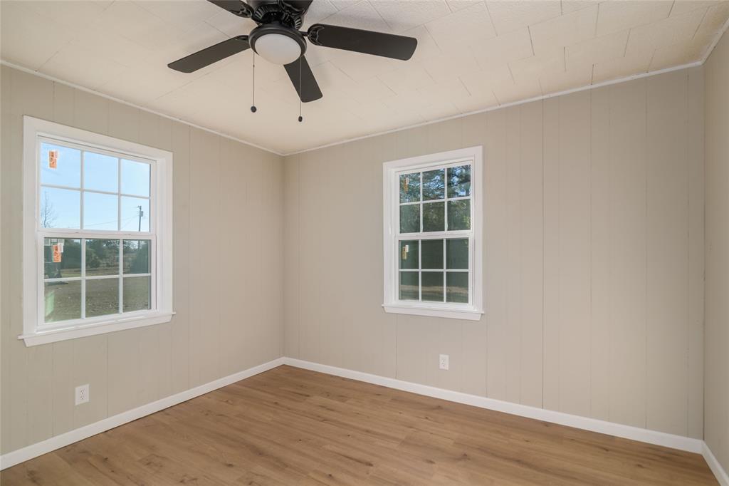 1456 Cooper Street Saline, LA 71070 - Photo 19 of 24 an empty room with wooden floor windows and fan