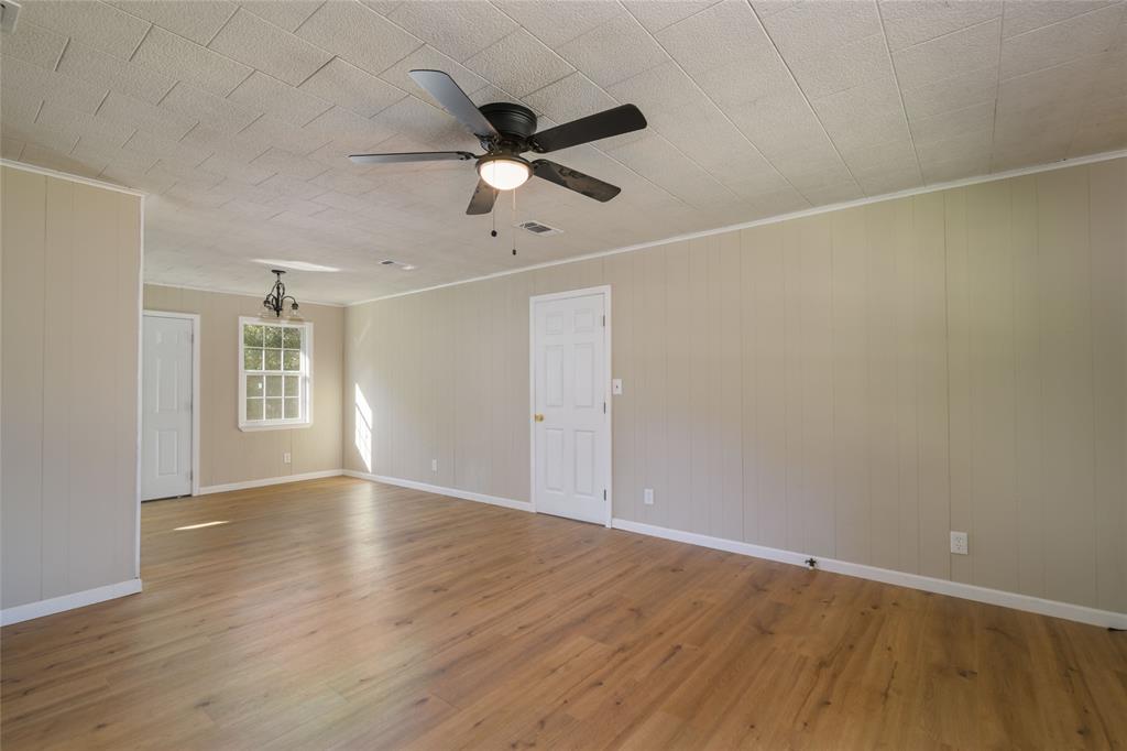 1456 Cooper Street Saline, LA 71070 - Photo 6 of 24 an empty room with wooden floor fan and windows