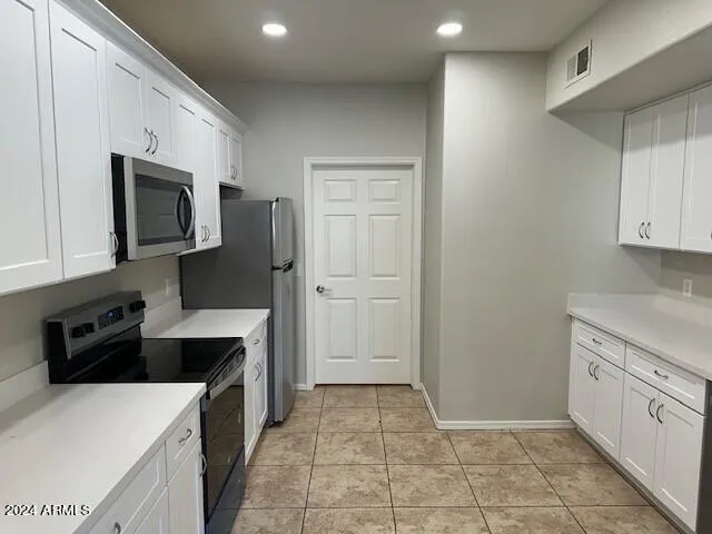 a kitchen with a refrigerator sink and cabinets