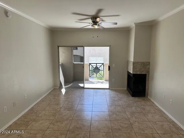 a view of an empty room with a fireplace and a chandelier fan