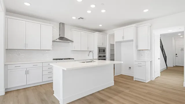 a kitchen with a sink stove and cabinets