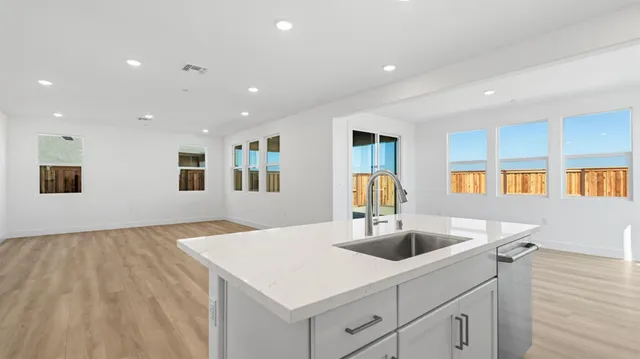 a kitchen with stainless steel appliances a sink a stove and cabinets