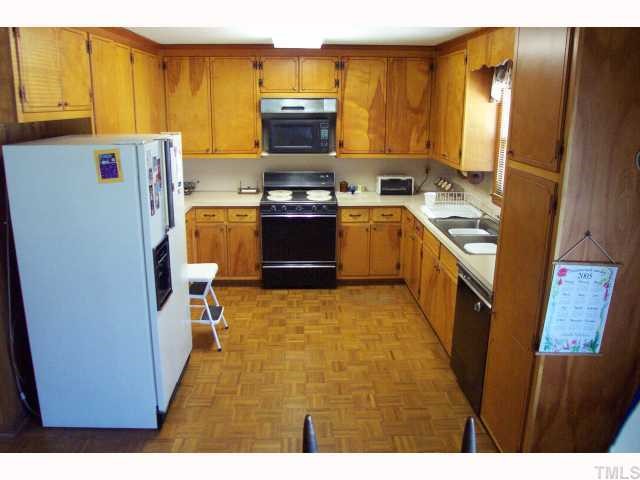 319 Sherron Road Durham, NC 27703 - Photo 3 of 6 a kitchen with stainless steel appliances a stove a refrigerator a sink a stove with wooden floor