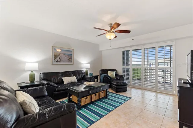 a living room with furniture ceiling fan and a window