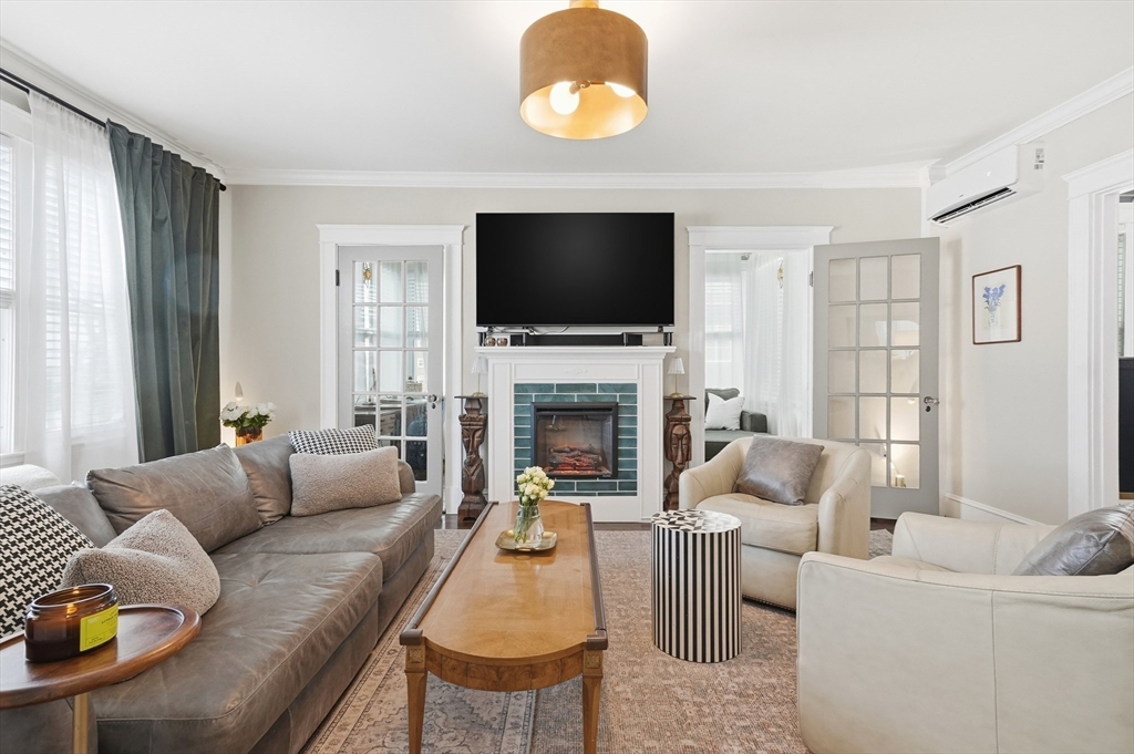 13 Roslyn Street, Unit 2 Salem, MA 01970 - Photo 3 of 26 a living room with furniture a flat screen tv and a fireplace