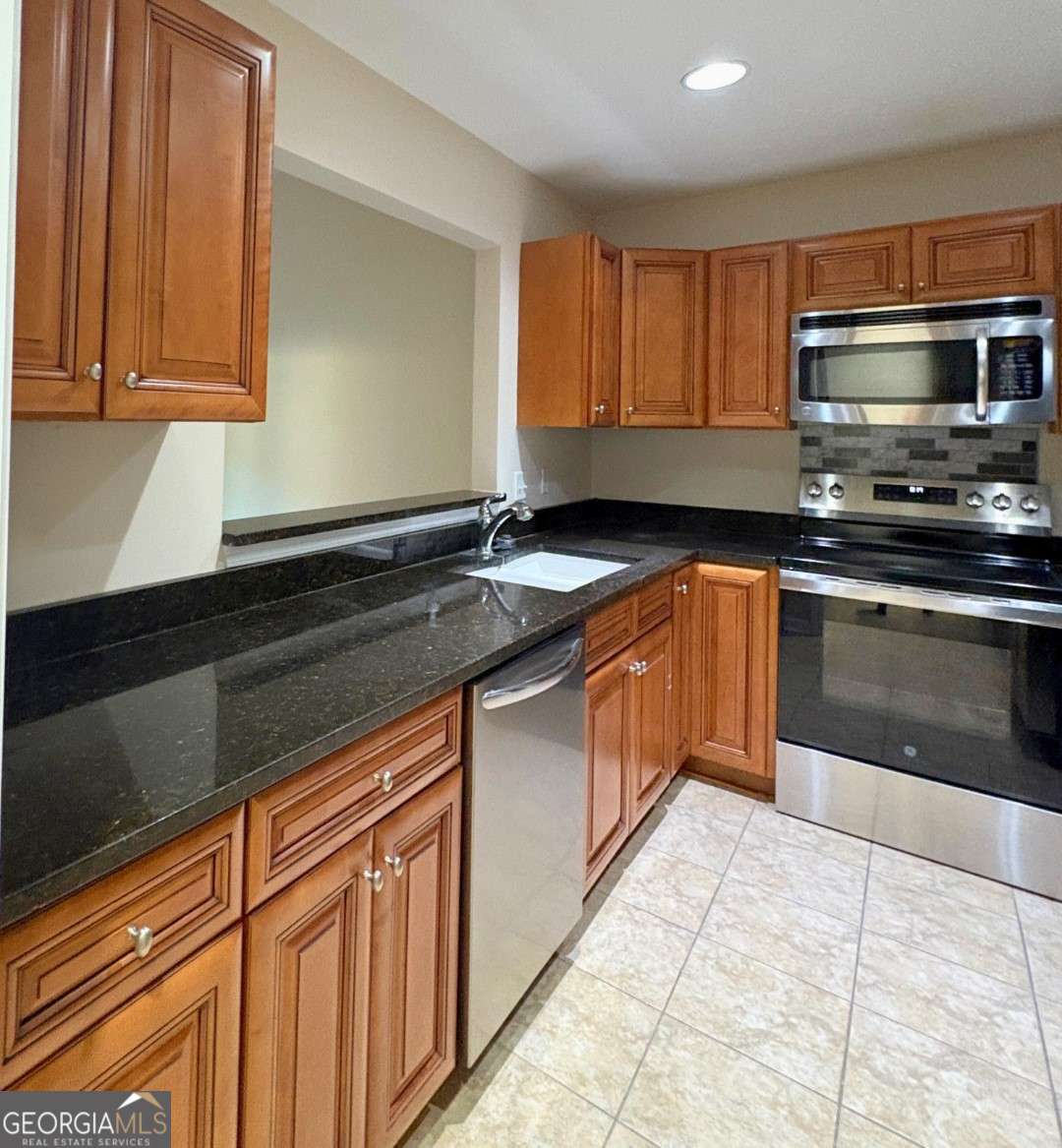 303 Gary Circle St. Marys, GA 31558 - Photo 11 of 42 a kitchen with stainless steel appliances granite countertop a sink stove and microwave