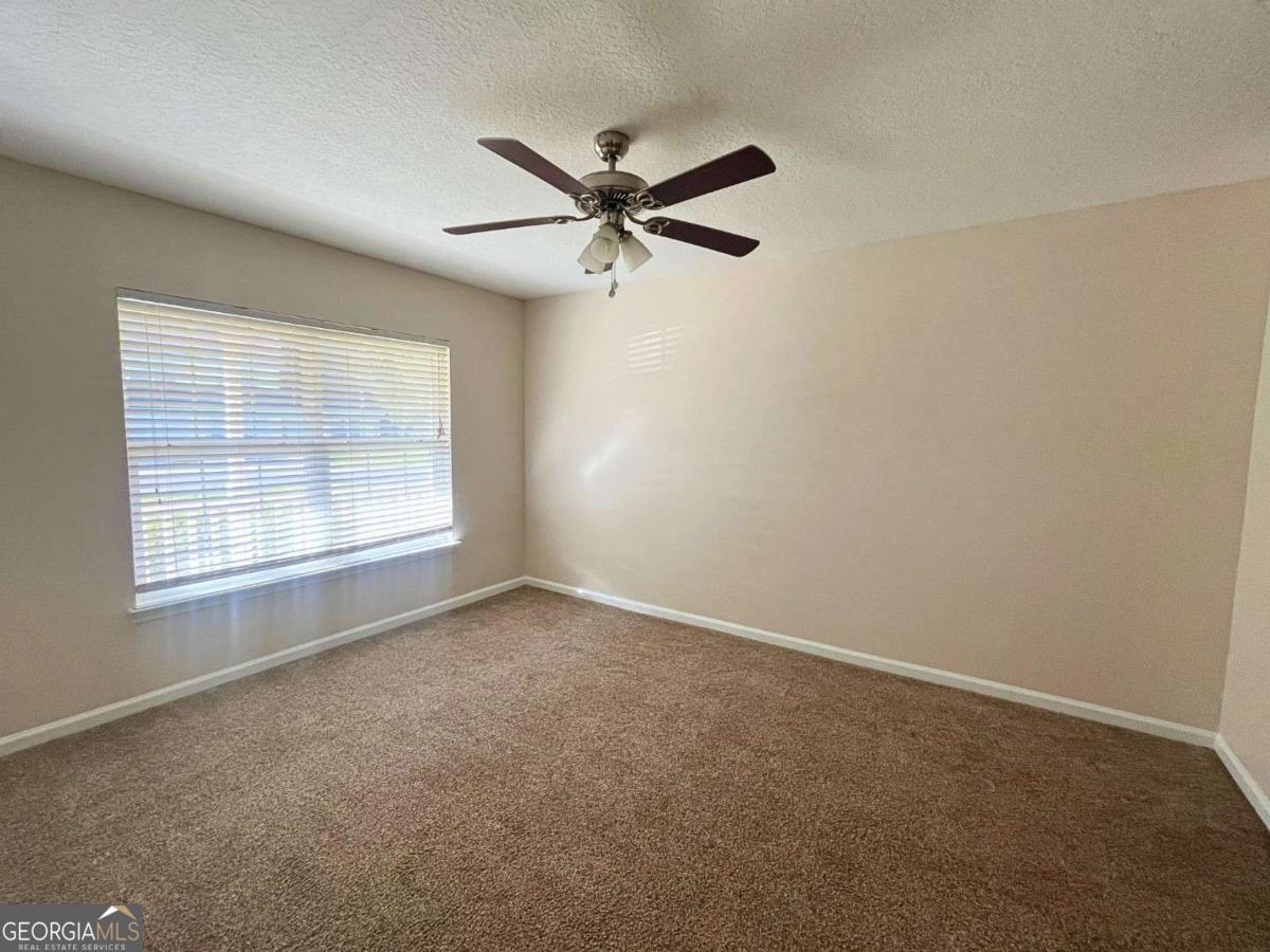 303 Gary Circle St. Marys, GA 31558 - Photo 15 of 42 an empty room with a window and a fan