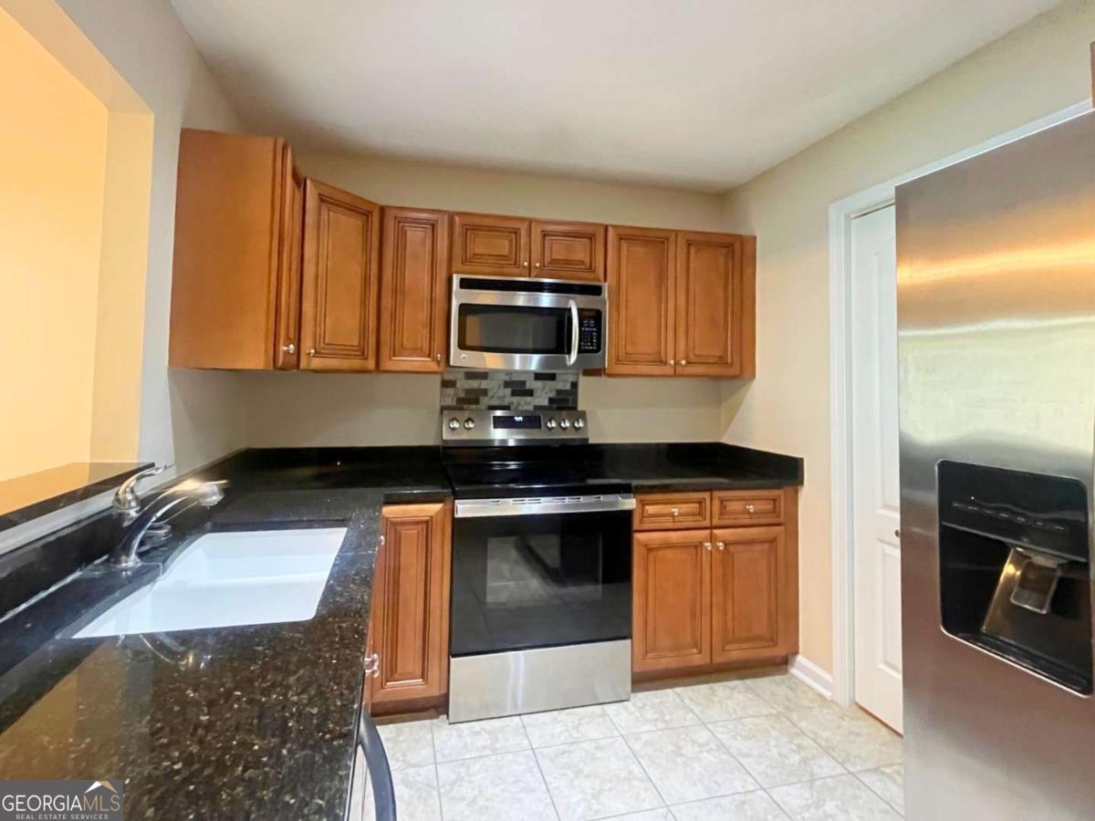 303 Gary Circle St. Marys, GA 31558 - Photo 8 of 42 a kitchen with stainless steel appliances granite countertop a stove a sink and a microwave
