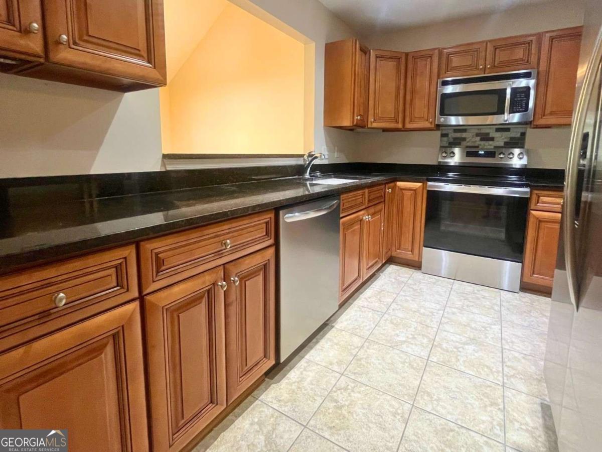 303 Gary Circle St. Marys, GA 31558 - Photo 9 of 42 a kitchen with stainless steel appliances granite countertop a stove a sink and a microwave