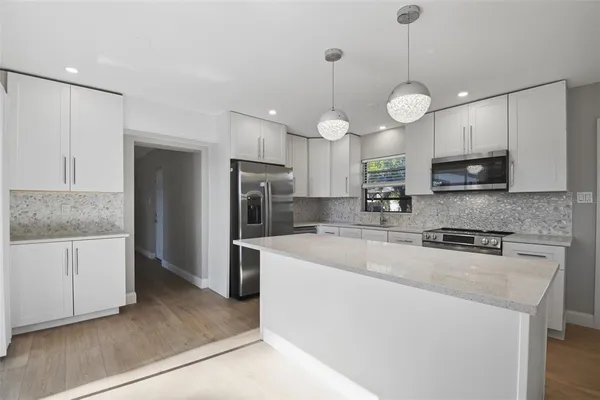 a kitchen with stainless steel appliances a sink stove and microwave