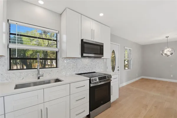 a kitchen with stainless steel appliances granite countertop a sink a stove a microwave and a refrigerator