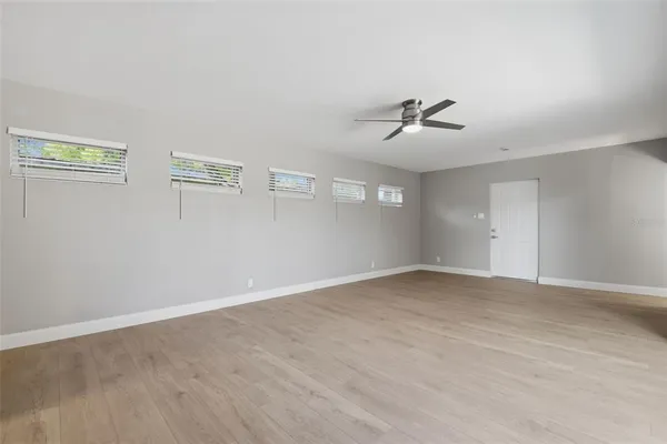 a view of a room with a ceiling fan and window