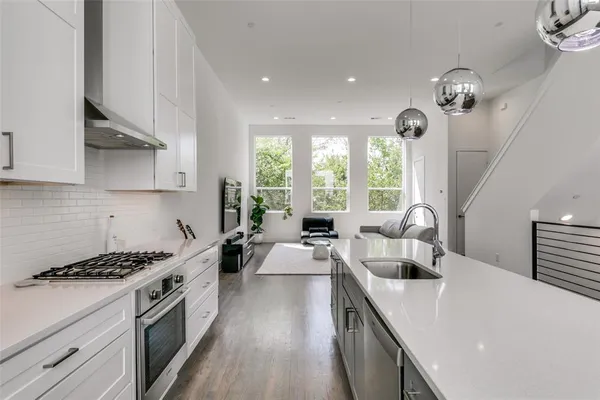 a large kitchen with stainless steel appliances a lot of counter space a sink and a window