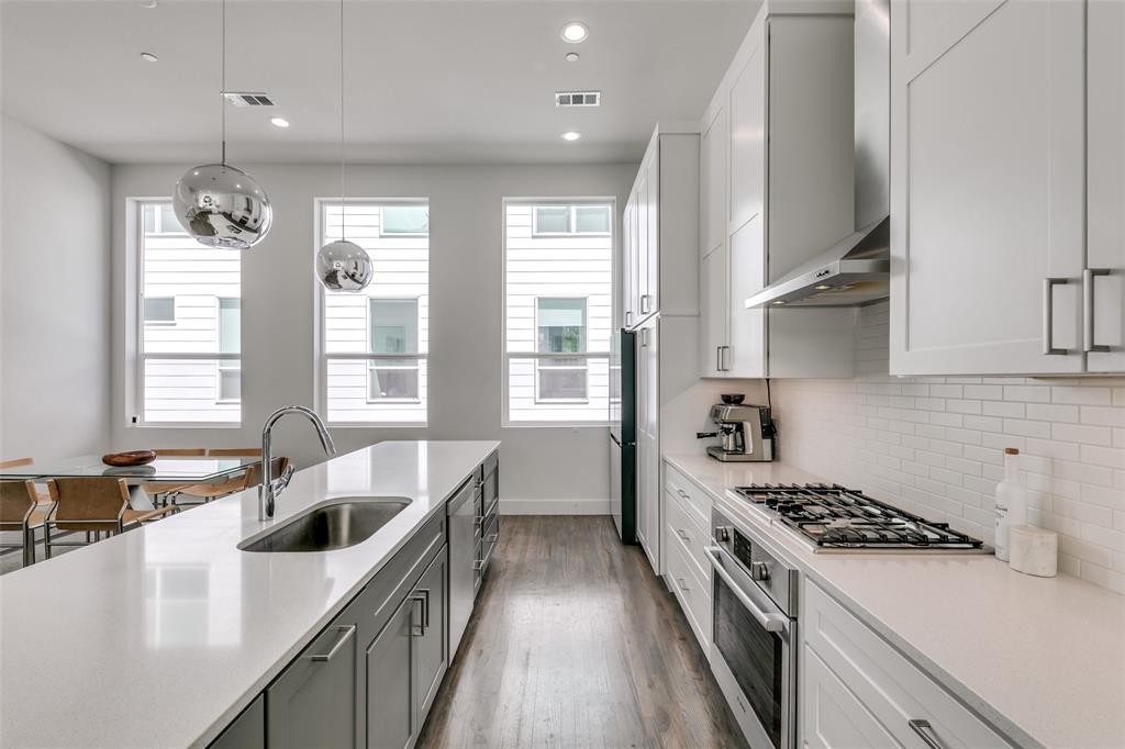 2908 Raleigh Street, Unit 204 Dallas, TX 75219 - Photo 14 of 25 a kitchen with stainless steel appliances granite countertop a sink a stove and a wooden floors