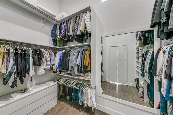 a view of walk in closet with clothes and shoes