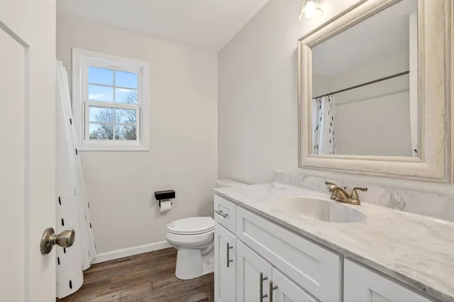 a bathroom with a granite countertop toilet sink and mirror
