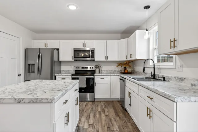 a kitchen with granite countertop a sink stove and refrigerator