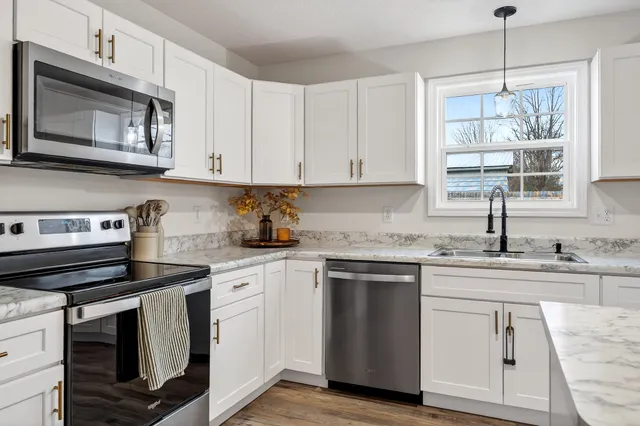 a kitchen with cabinets appliances a sink and a window