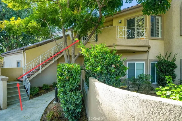 a view of a house with a yard and potted plants