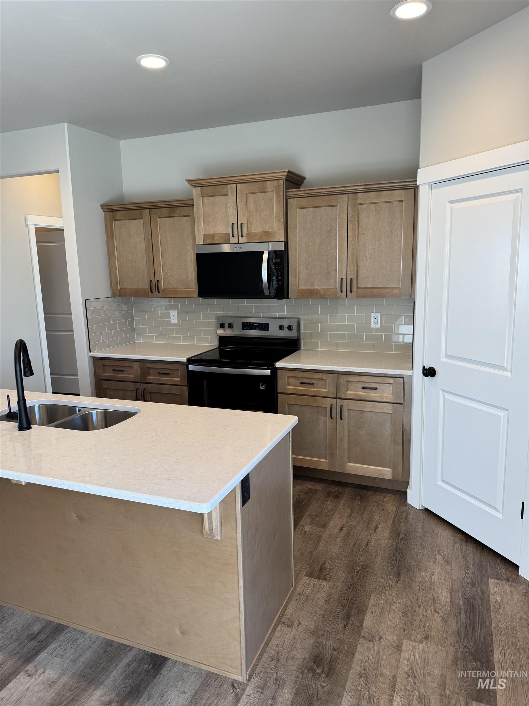 2064 Harrison Street South Twin Falls, ID 83301 - Photo 2 of 29 Kitchen featuring stainless steel appliances, light stone counters, dark wood-style flooring, decorative backsplash, and recessed lighting