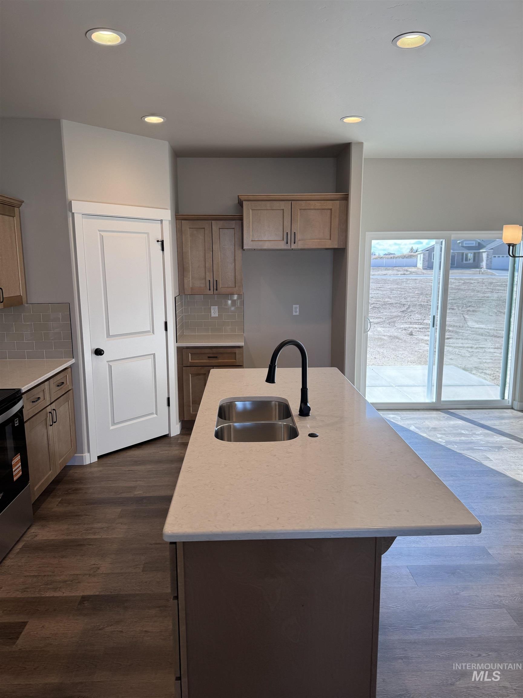 2064 Harrison Street South Twin Falls, ID 83301 - Photo 3 of 29 Kitchen with light stone countertops, stainless steel range with electric stovetop, an island with sink, decorative backsplash, and recessed lighting