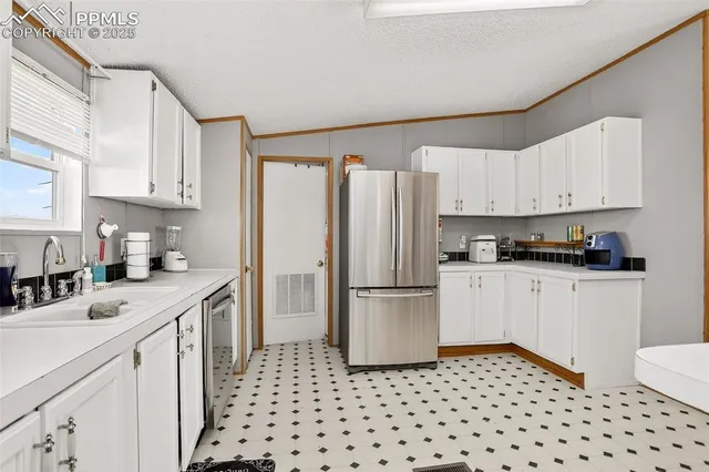 a kitchen with a refrigerator a white cabinets and black appliances
