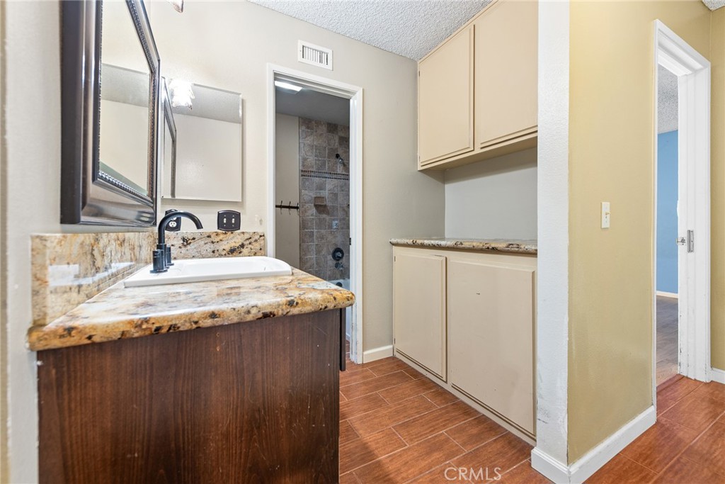 3208 Gibraltar Dr. Riverside, CA 92506 - Photo 24 of 37 a bathroom with a granite countertop sink and a mirror