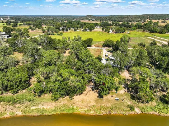 an aerial view of residential houses with outdoor space and lake view