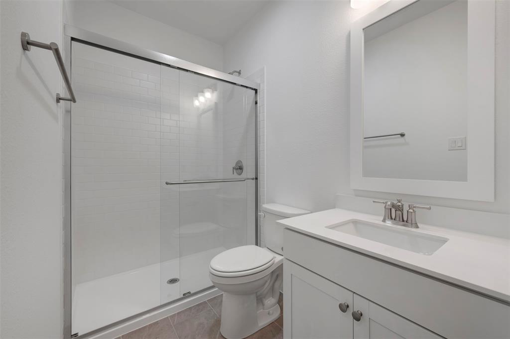 1004 Ashcroft Lane Justin, TX 76247 - Photo 18 of 39 a bathroom with a shower a sink a toilet and shower