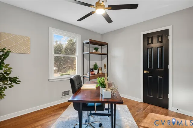 a view of a workspace with furniture and a window
