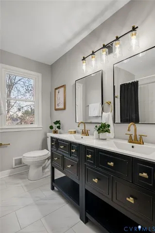 a spacious bathroom with a granite countertop sink mirror and toilet