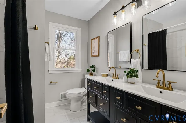 a bathroom with a double vanity sink a toilet and a mirror