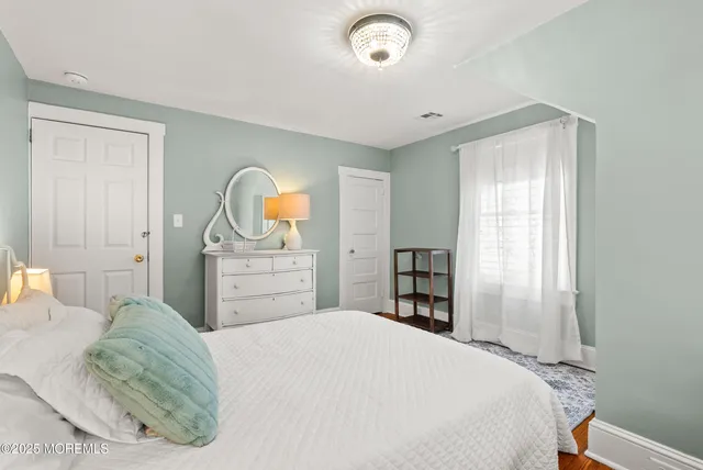 a bedroom with a bed window tv and a window