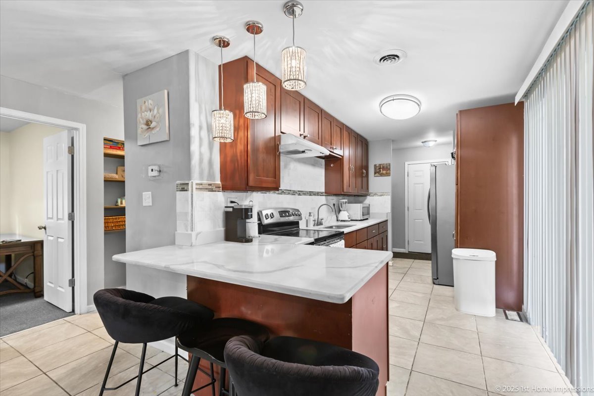 16340 Justine Street Markham, IL 60428 - Photo 6 of 19 a kitchen with stainless steel appliances a sink stove and refrigerator