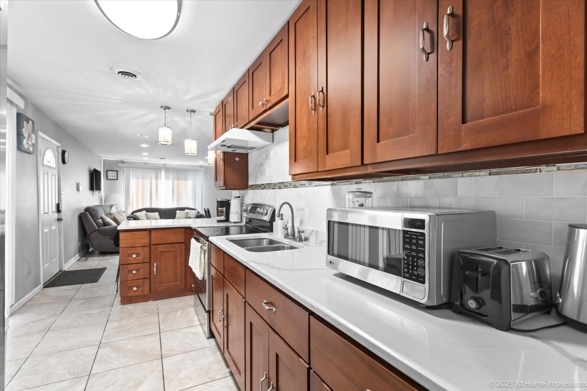 16340 Justine Street Markham, IL 60428 - Photo 8 of 19 a kitchen with stainless steel appliances granite countertop a sink a stove and cabinets