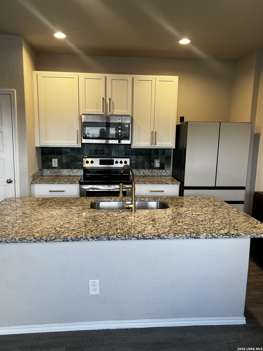 7602 Alameda Beach Converse, TX 78109 - Photo 14 of 39 a kitchen with a sink a counter top space cabinets and stainless steel appliances