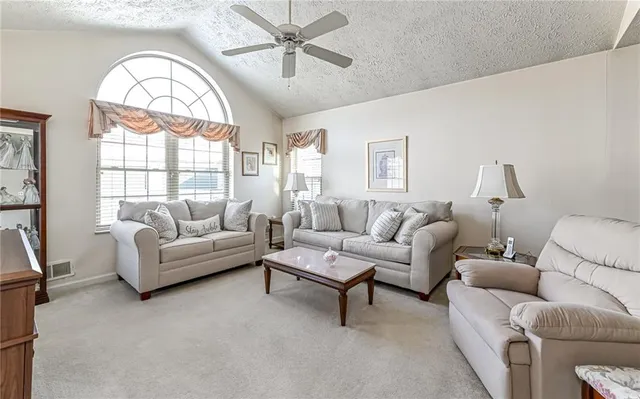 a living room with furniture a large window and a chandelier