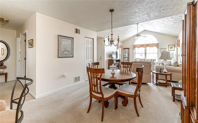 a view of a dining room with furniture and a chandelier