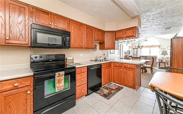 a kitchen with stainless steel appliances granite countertop a stove top oven a sink dishwasher and cabinets with wooden floor